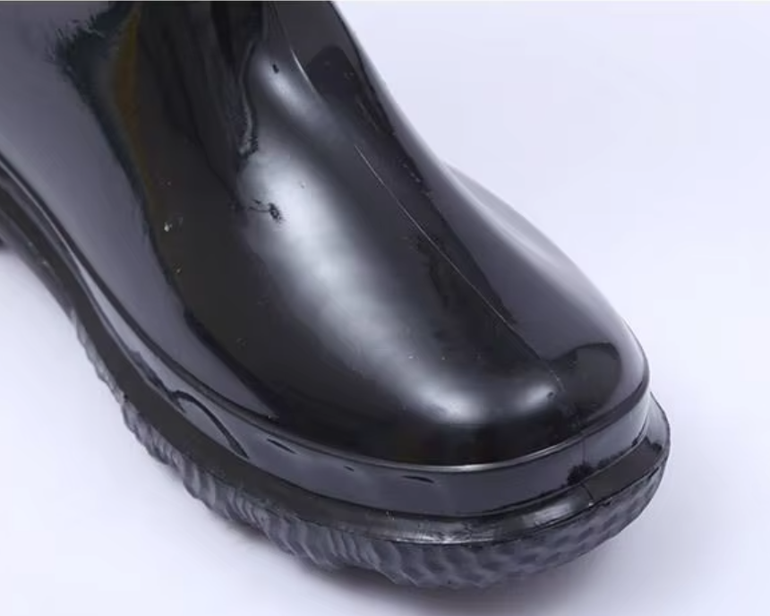a092bfdc-7822-4703-8756-0930a4d9c5b3_tampak-dekat-tapak-jari-kaki-yang-bulat-pada-but-kerja-kalis-air-pvc-hangat-hitam-berkilat.png